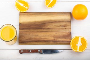 Taze meyve suyuyla birlikte dilimlenmiş portakal. Beyaz ahşap arka plan. Mesaj için yer var. Üst görünüm.