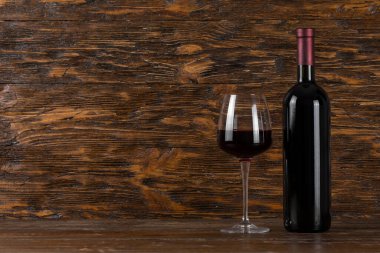 Ahşap arka planda şarap şişesi ve cam. Mesaj için yer var. Üst görünüm.