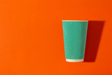 Turuncu arka planda kahve için kağıt bardak. Kahve hazır..