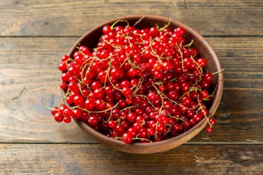 Ahşap zemin üzerinde taze kırmızı frenk üzümü..