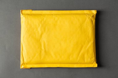 Gri arka planda sarı kağıt poşet. Uluslararası teslimatlar için paket. Metin için boşluk.
