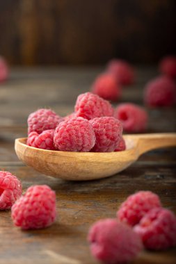 Ahşap kaşıkta taze ahududu. Böğürtlen vitamin bakımından zengindir..