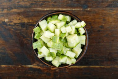 Ahşap arka planda bir kasede dilimlenmiş kabak. Sebze, malzeme ve zımba. Sağlıklı yemek..