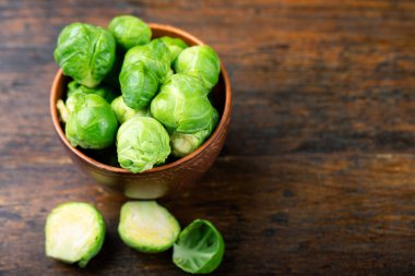 Tahta arka planda bir fincanda taze Bruxelles filizleri