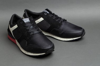 Gri arka planda bir çift şık siyah spor ayakkabı. İzole edilmiş ayakkabılar.