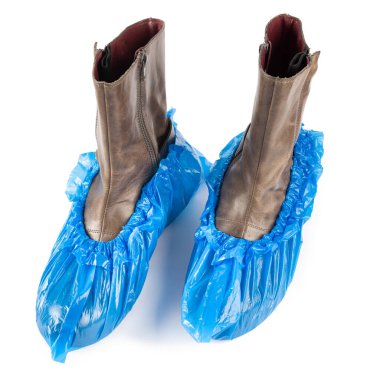 Beyaz arka planda izole edilmiş kadın ayakkabılarındaki mavi koruyucu ayakkabı kılıfları. Tıp kurumlarında hijyen ve temizlik.