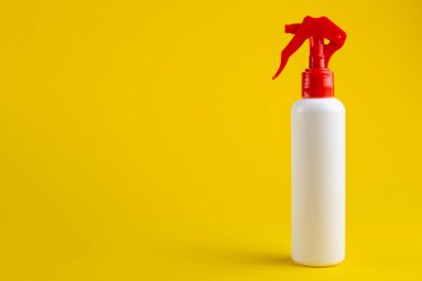 Sarı arka planda kırmızı kapaklı beyaz kozmetik sprey. Losyon, nemlendirici, deodorant ve su çeşitleri. Metin için boşluk.