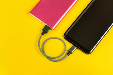 Sarı Arkaplan Görünümünde Pembe Güç Bankasıyla Akıllı Telefon Şarjı
