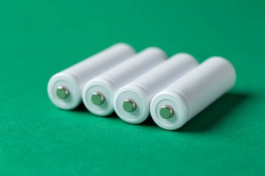 Yeşil arka planda beyaz AA bataryalar. Akümülatörlerin en popüler boyutu. Boşluğu kopyala.