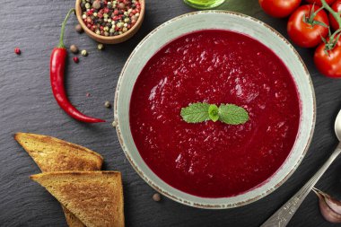 İştah açıcı yaz domates çorbası püre gazpacho siyah arka planda kasede servis edilir. Üst görünüm.