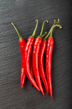Siyah tahtada kırmızı kırmızı biber. Üst görünüm.