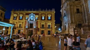 Malaga, İspanya. Ekim 2017 civarı. İnsanlar geceleri yürüyor. Arkaplanda katedral.