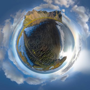 Güneşli bir günde Stokksnes 'teki siyah kumlu plajın üzerinde uçan destansı hava aracı görüntüsü. Arka planda Vestrahorn Dağı var. Fisheye çarpık panorama. Doğa ve ekoloji kavramı küçük bir gezegen..