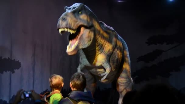 Дети смотрят аниматронику тираннозавра в музее естественной истории — стоковое видео