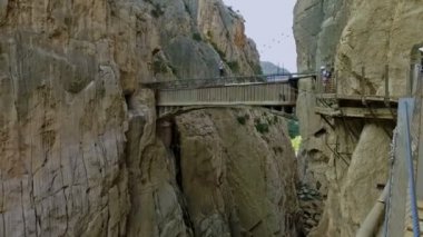 İspanya 'nın Malaga bölgesindeki Gorge Chorro' da bulunan Royal Trail 'deki (El Caminito del Rey) asma köprüden geçen insanlar