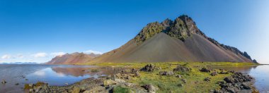 Güneşli bir günde Stokksnes 'teki siyah kumlu sahilin destansı manzarası. Arka planda Vestrahorn Dağı var. Doğa ve ekoloji kavramı.