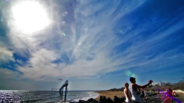 Avión aterrizando cerca de la orilla del mar con cielo azul y nubes — Vídeo de stock