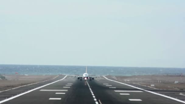 Un aereo che decolla in un aeroporto con il mare sullo sfondo — Video Stock