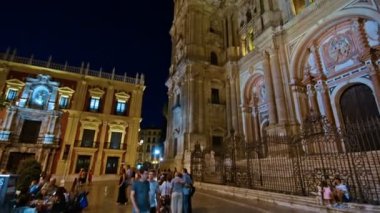 Malaga, İspanya. Ekim 2017 civarı. İnsanlar geceleri yürüyor. Arkaplanda katedral.