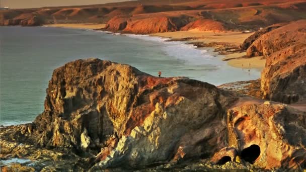 Hombre Escalando Una Roca Una Playa Atardecer — Vídeos de Stock