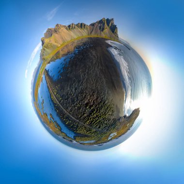 Güneşli bir günde Stokksnes 'teki siyah kumlu plajın üzerinde uçan destansı hava aracı görüntüsü. Arka planda Vestrahorn Dağı var. Balık gözü çarpık manzara.