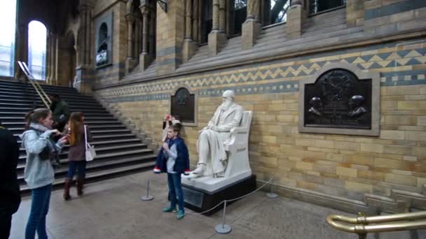 Kid taking a picture with Charles Darwin statue — Stock Video