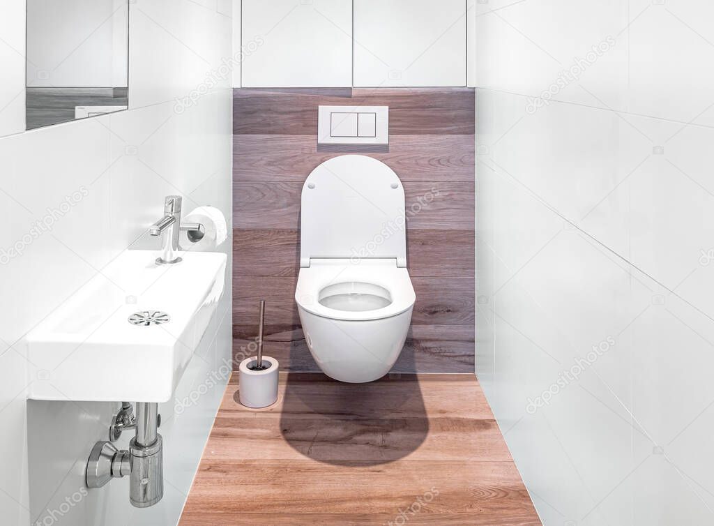 Small bathroom interior with white tiles and fake wooden floor. Original designed toilet space with modern minimal pieces.