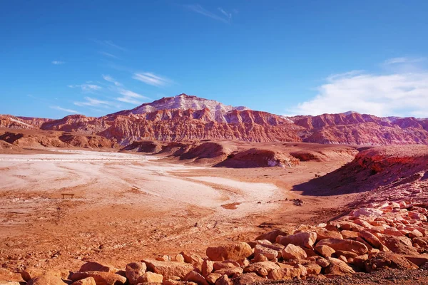 Pouštní krajina v měsíčním údolí nedaleko San Pedro de Atacama, v severní části Chile, proti modré obloze pokryté mraky. — Stock fotografie