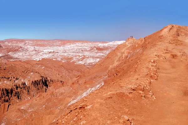 Pouštní krajina v měsíčním údolí nedaleko San Pedro de Atacama, v severní části Chile, proti modré obloze pokryté mraky. — Stock fotografie