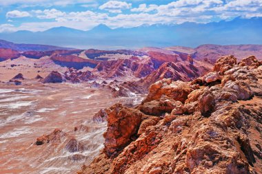 San Pedro de Atacama yakınlarındaki Ay Vadisi'nin çöl manzarası, Şili'nin kuzey kesiminde, bulutlarla kaplı mavi bir gökyüzüne karşı.