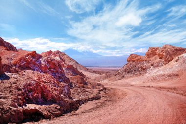 San Pedro de Atacama yakınlarındaki Ay Vadisi'nin çöl manzarası, Şili'nin kuzey kesiminde, bulutlarla kaplı mavi bir gökyüzüne karşı.