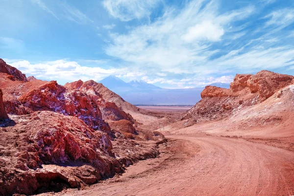 Pouštní krajina v měsíčním údolí nedaleko San Pedro de Atacama, v severní části Chile, proti modré obloze pokryté mraky. — Stock fotografie