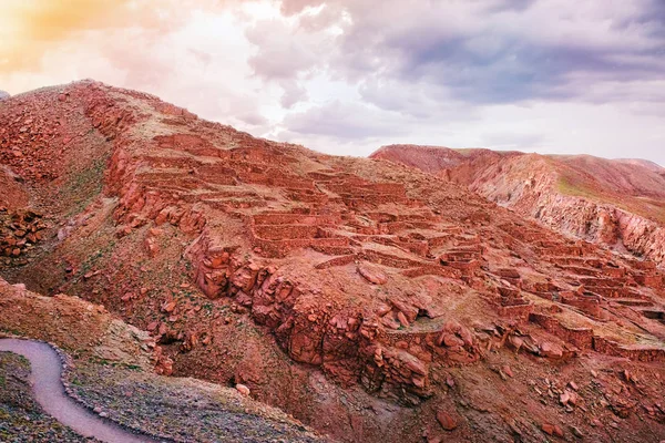 Pouštní krajina archeologického městečka Pukara de Quitorand nedaleko San Pedro de Atacama v Chile, proti obloze slunce, pokryté mraky. — Stock fotografie