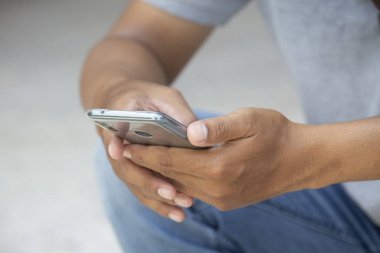 Alan ile akıllı telefon kullanarak Asyalı adam genç Closeup el. 