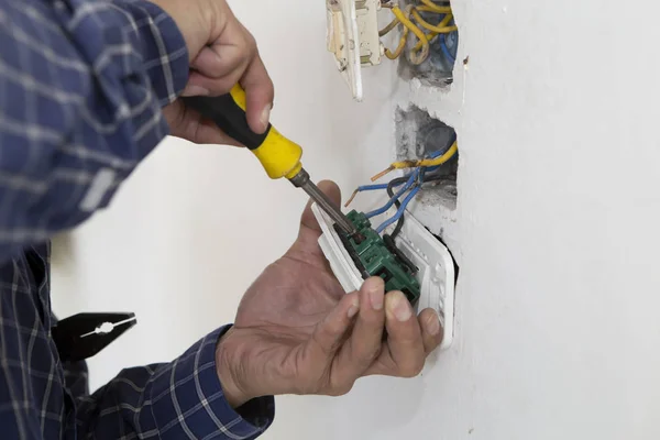 Elektrik prizinde çalışan elektrikçi. Onarım konsepti.