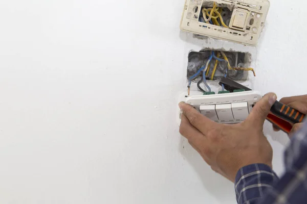 Electrician working at plug socket. Repair concept.