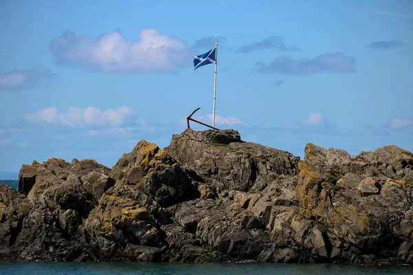 Bandera escocesa y ancla oxidante en un puerto escocés — Foto de Stock
