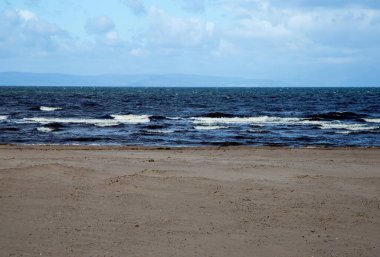 Mavi deniz ve dalgalar ıssız bir sahilde