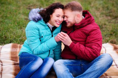 bir termos ekose ve içecek kahve oturan genç Çift