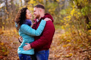 Aşıklar sonbahar parkında el ele yürür