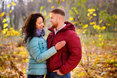 Aşıklar sonbahar parkında el ele yürür