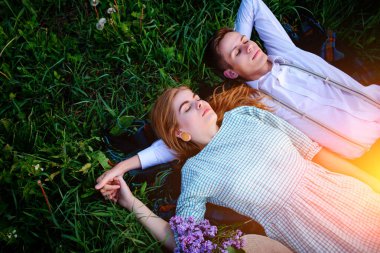 Genç çift çim üzerinde yalan ve sakin ol, yukarıdan görüntülemek.