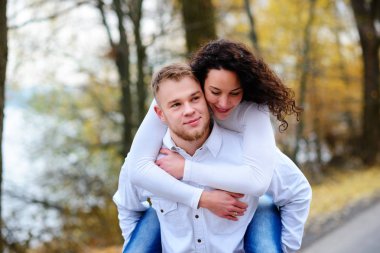 Aşıklar sonbahar parkında el ele yürür