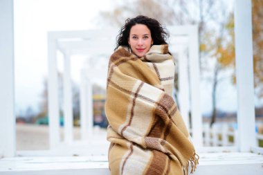 muhteşem sonbahar günü sahilde bir battaniye giymiş güzel kız