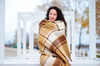 muhteşem sonbahar günü sahilde bir battaniye giymiş güzel kız