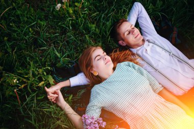 Genç çift çim üzerinde yalan ve sakin ol, yukarıdan görüntülemek.