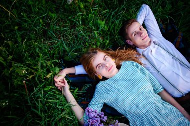 Genç çift çim üzerinde yalan ve sakin ol, yukarıdan görüntülemek.