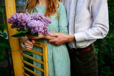 adam bir buket leylak tutan kız arkadaşı sarılma.