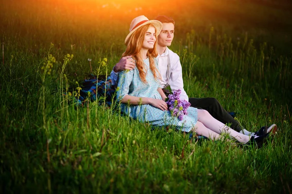 年轻夫妇坐在公园里格子上 看着夕阳 — 图库照片