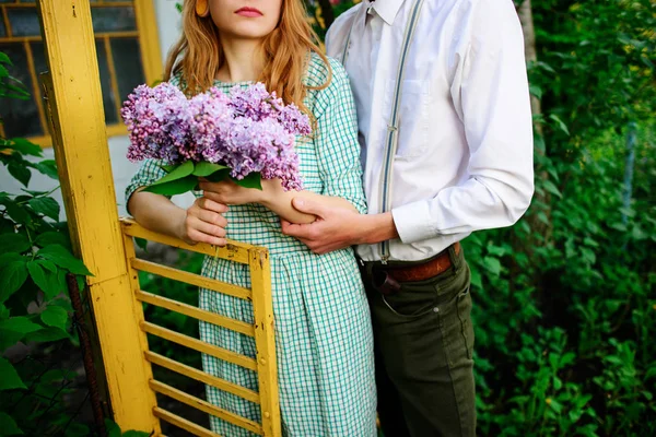 adam bir buket leylak tutan kız arkadaşı sarılma.